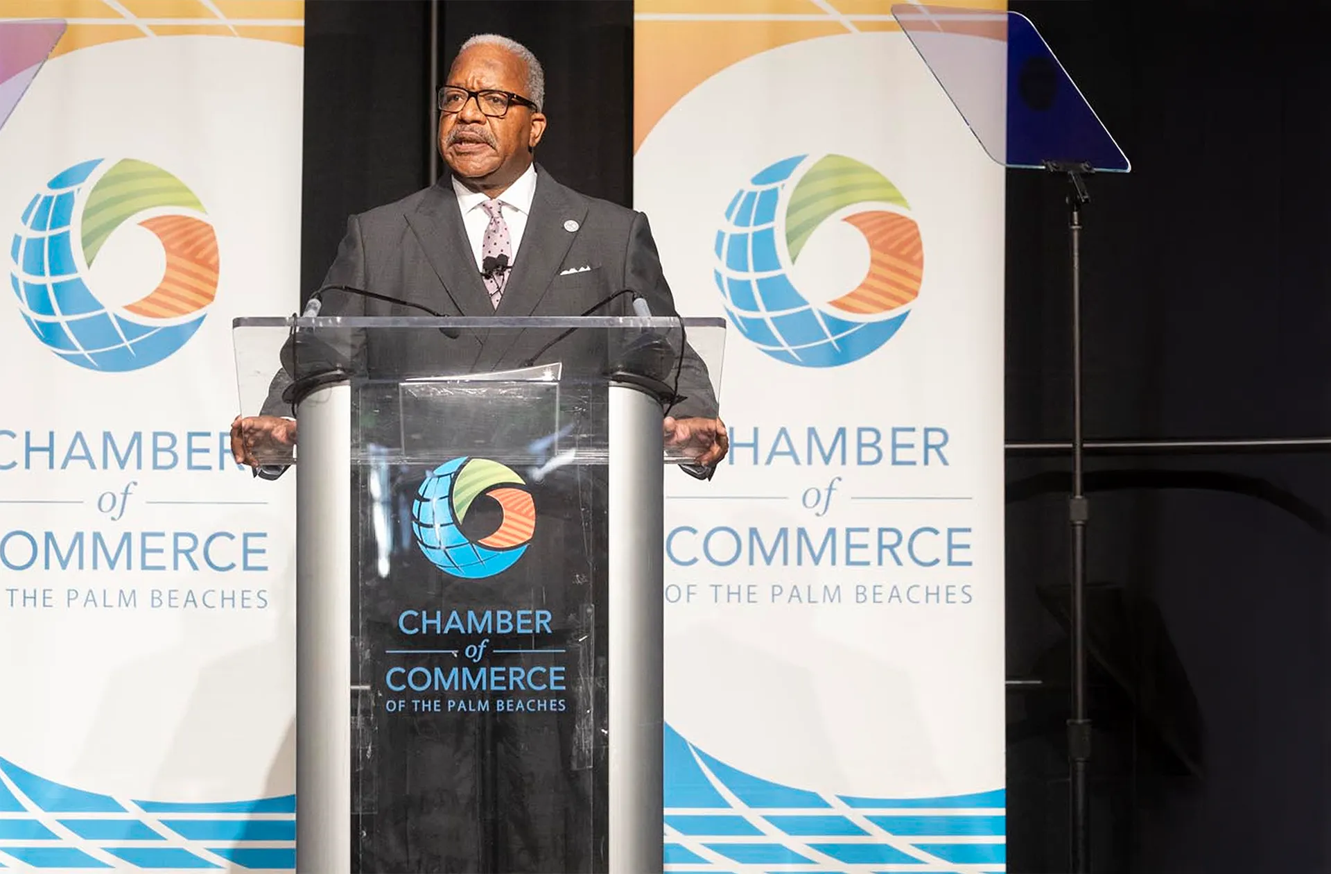 Mayor of West Palm Beach speaks on stage at the Chamber breakfast.